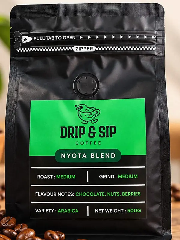The Nyota Blend bag in daylight on a wooden table with coffee beans. Its green label reads Roast: Medium, Grind: Medium, Flavour notes: chocolate, nuts, berries, Net weight: 500 g